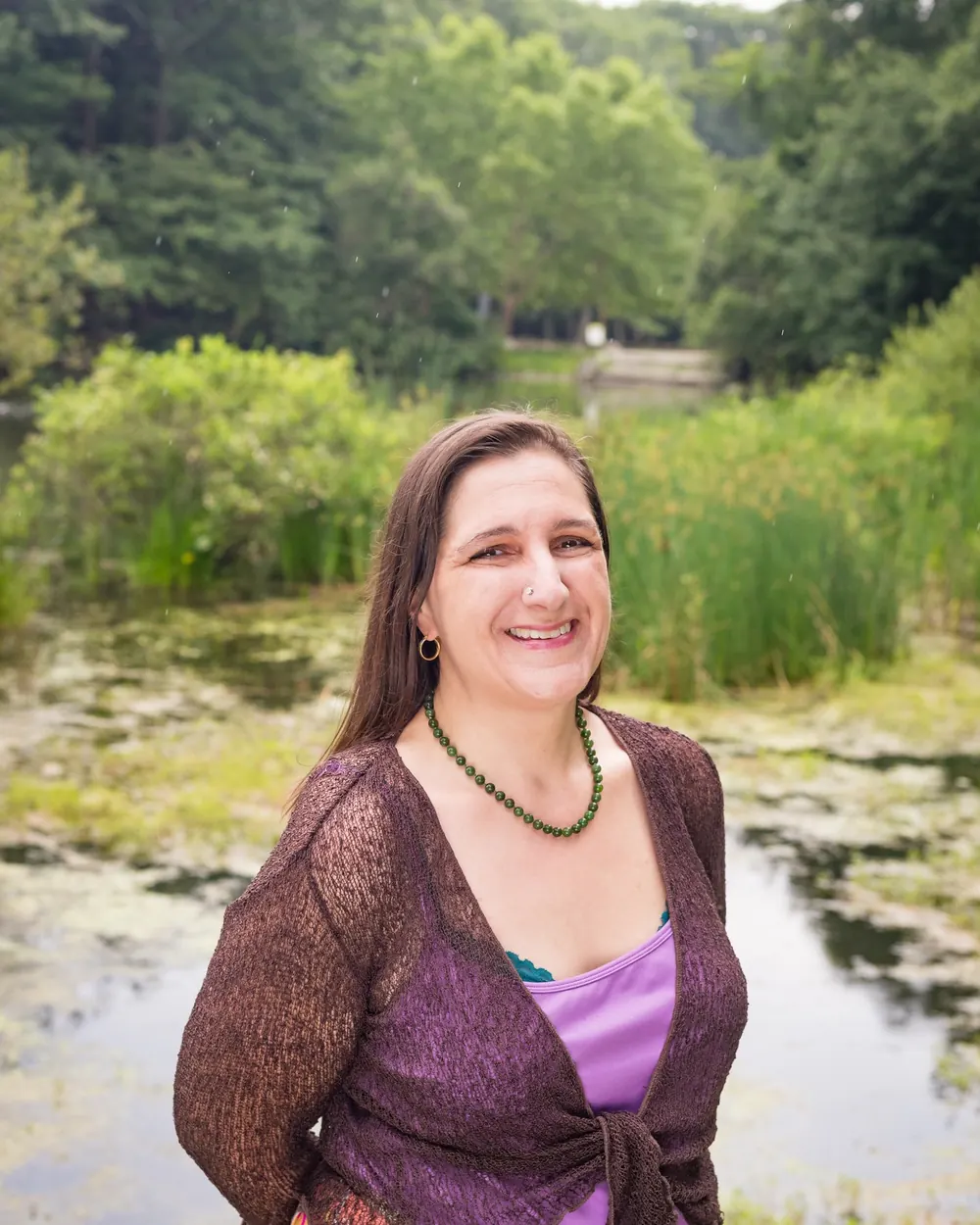 Kara Katz smiling beside a pond with tall reeds